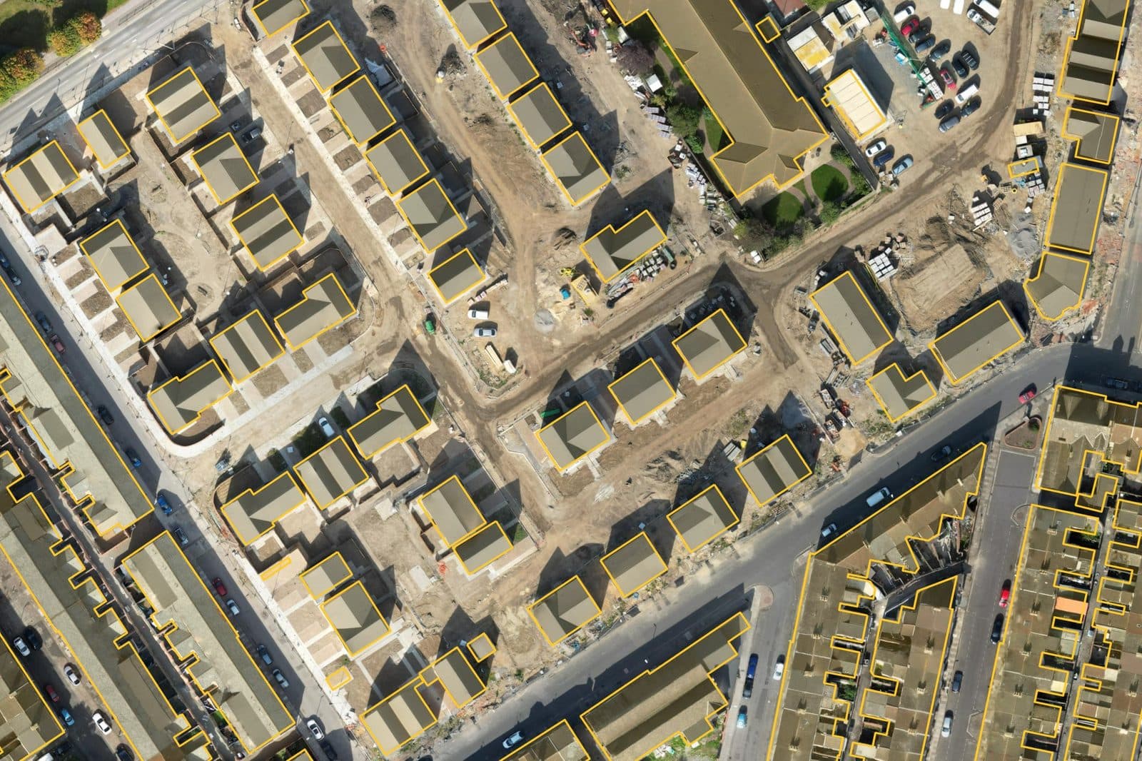 Aerial photo of a new-build estate of semi-detached and detached houses under construction, roofs outlined in amber.